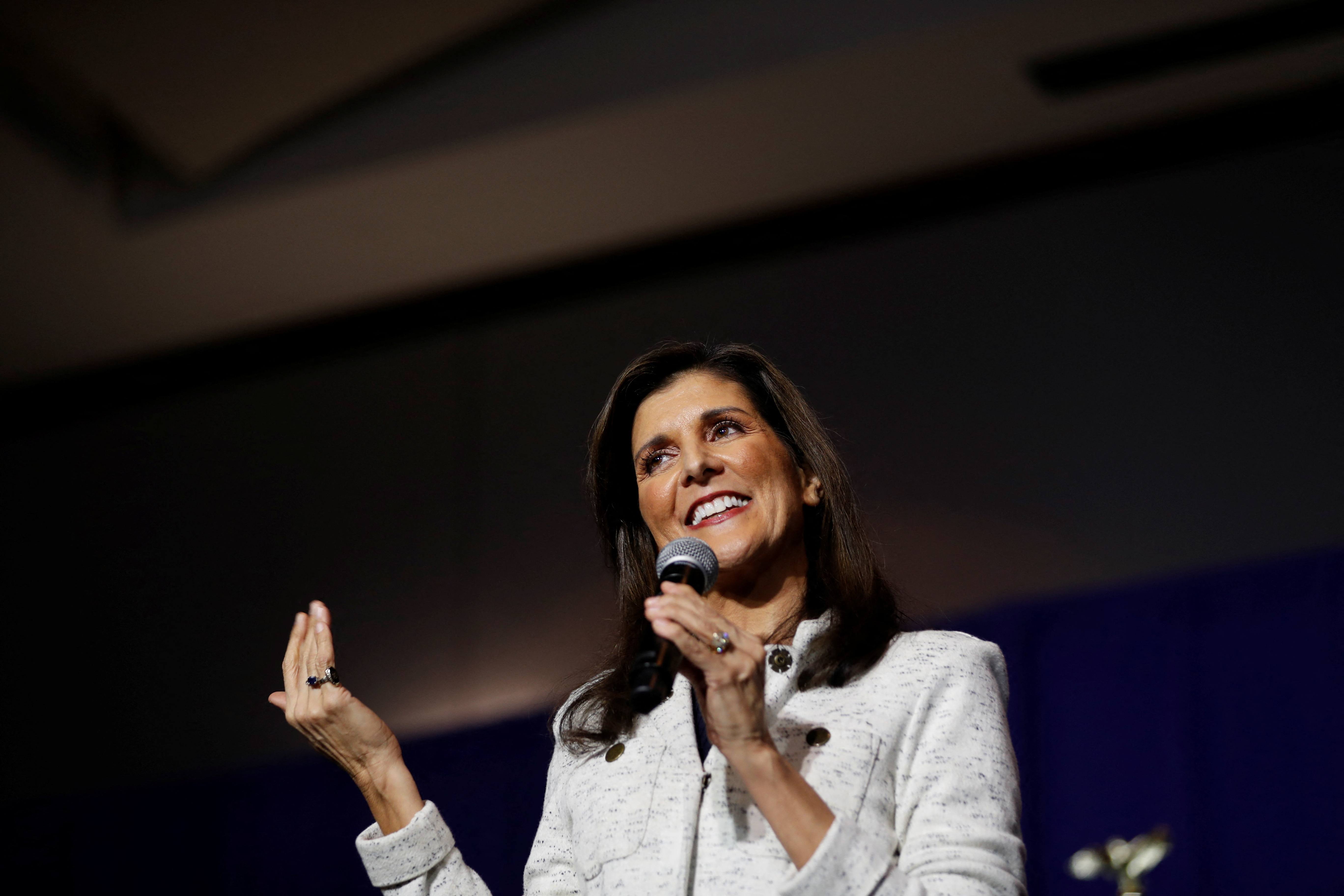 Nikki Haley speaks at a campaign event in South Carolina, standing at a podium with a microphone in front of an American flag backdrop.