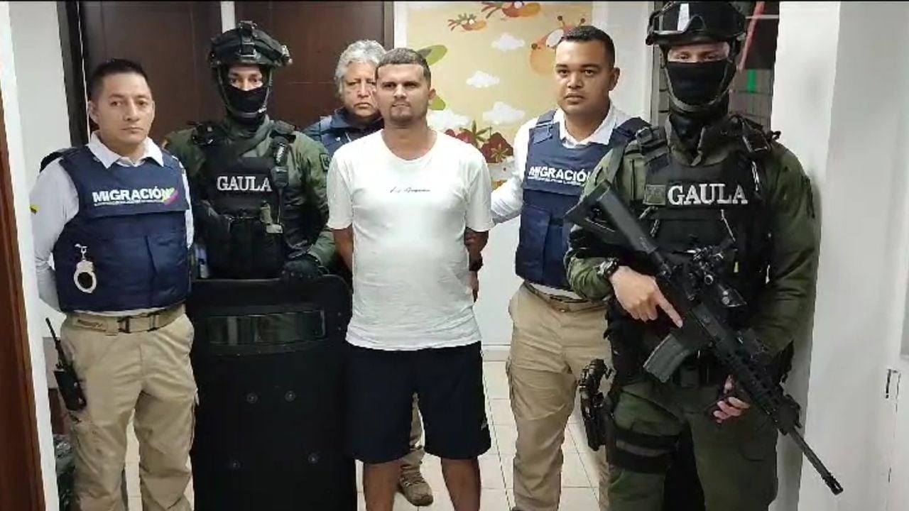 Men in uniform escorting a man in handcuffs who is identified as alias Satan during deportation to Colombia. Archive image.
