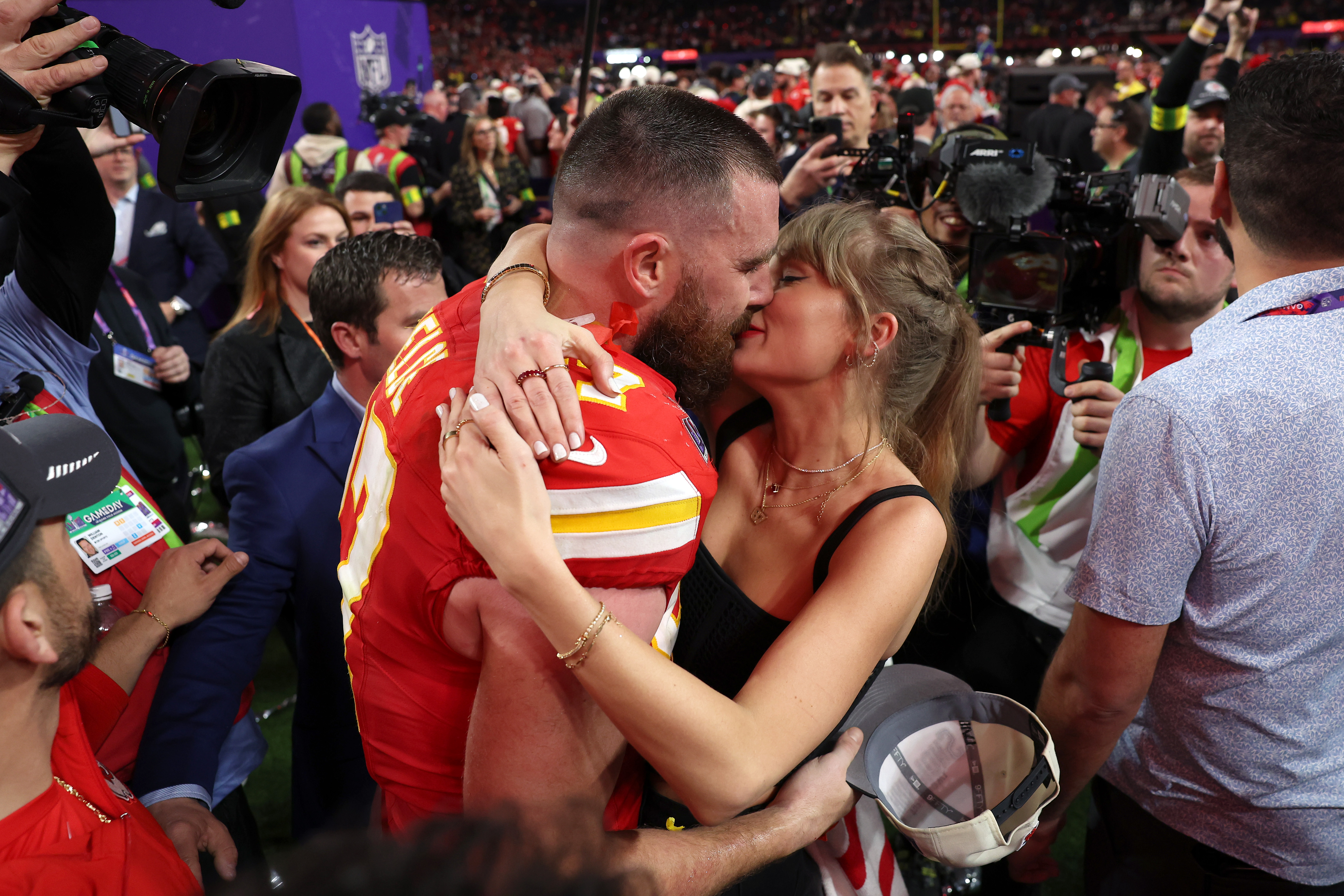 Travis Kelce and Taylor Swift kiss after Chiefs' Super Bowl 2024 win.
