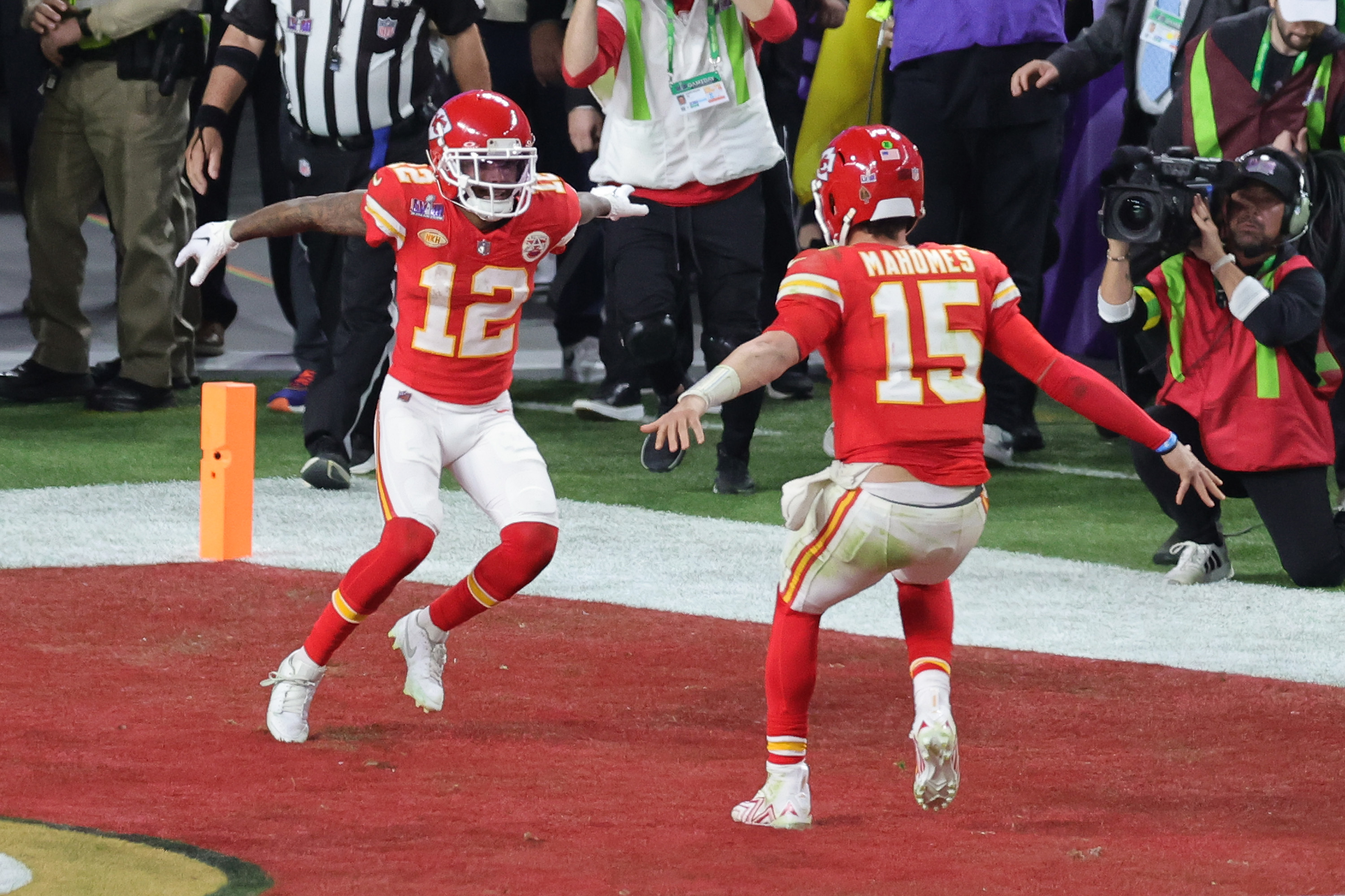 Patrick Mahomes and Mecole Hardman celebrating their game-winning touchdown on the football field during Super Bowl LVIII, with LeSean McCoy nearby.