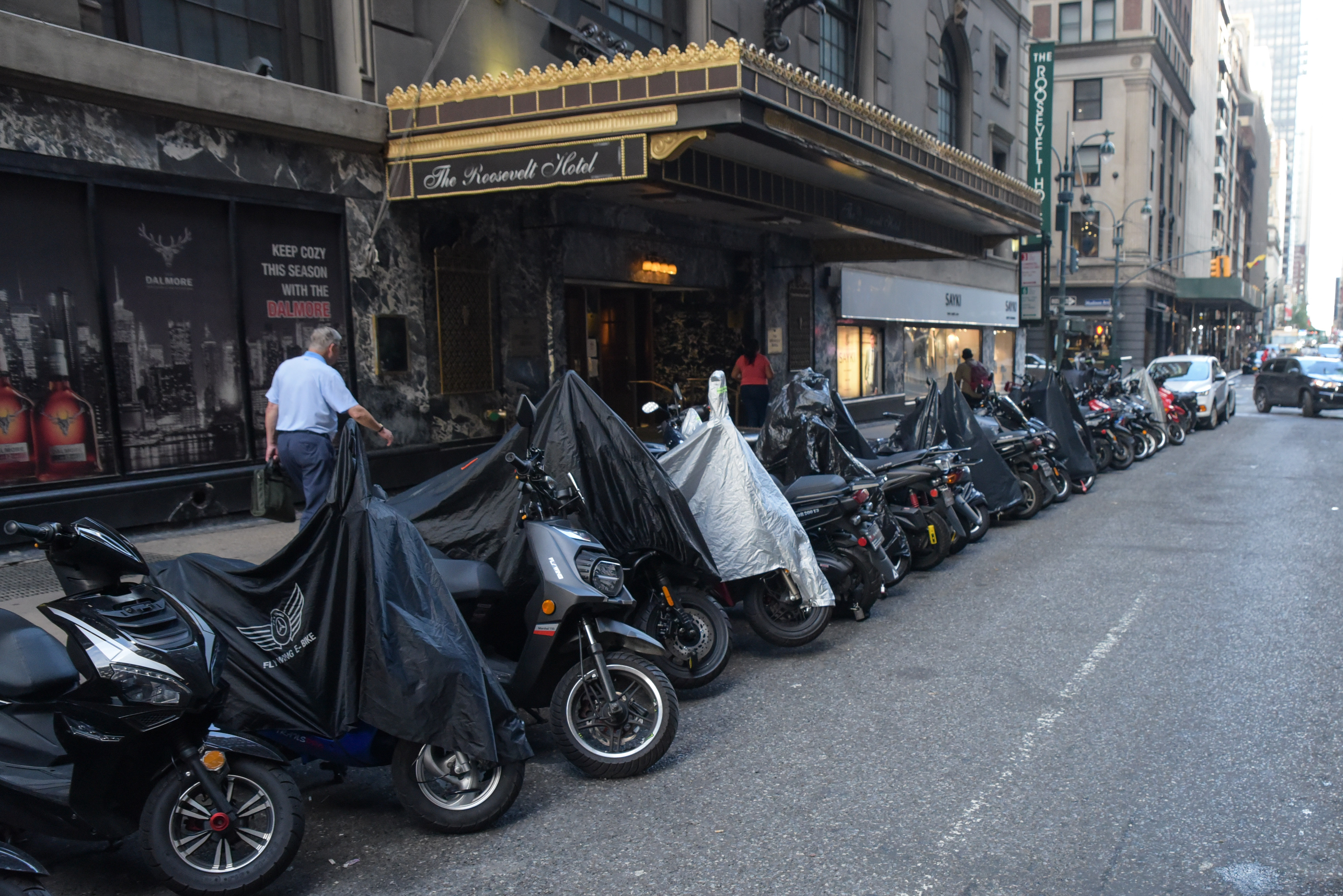 A row of motorcycles parked on the side of a street.